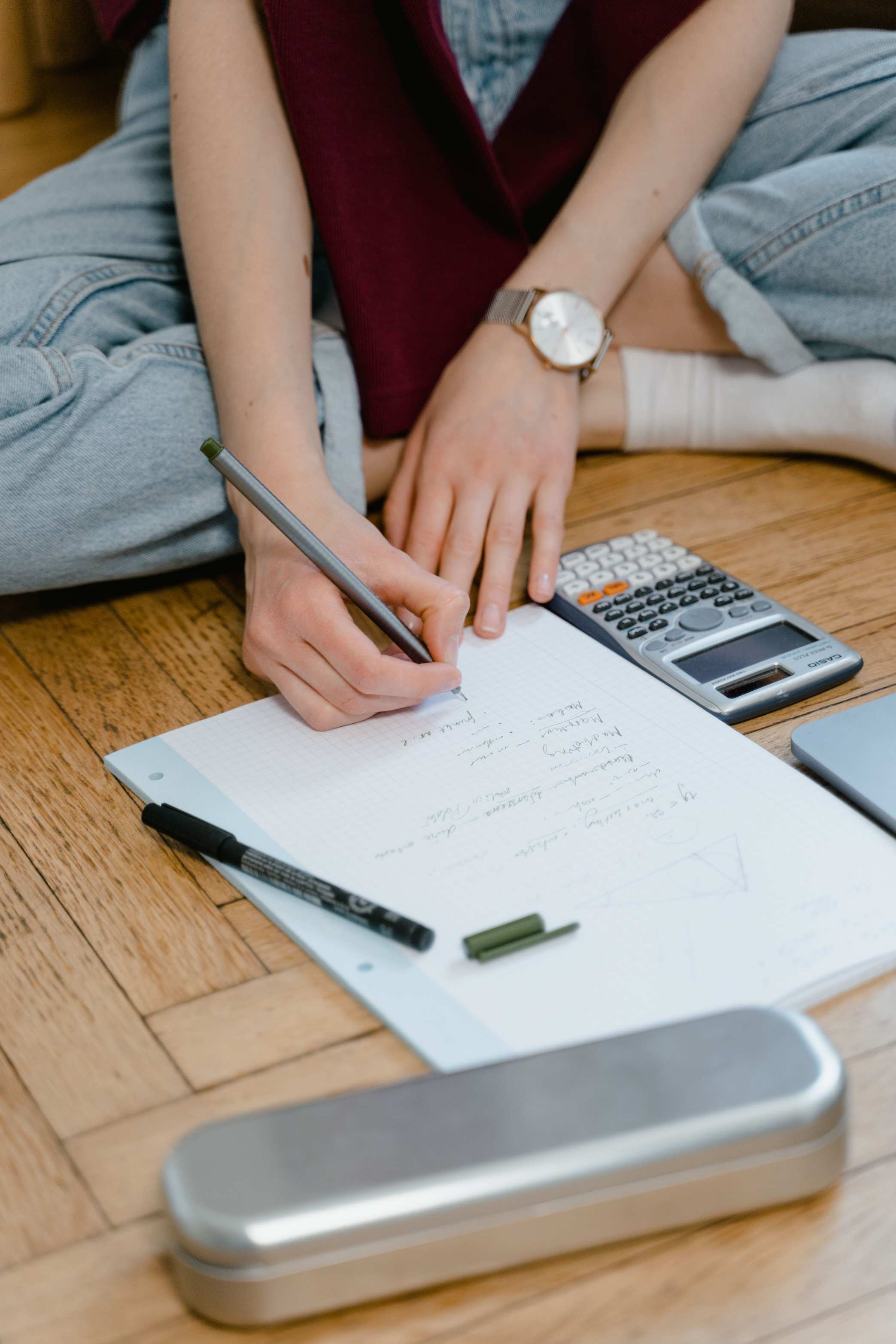 Notizen auf Papier mit Taschenrechner und Stift